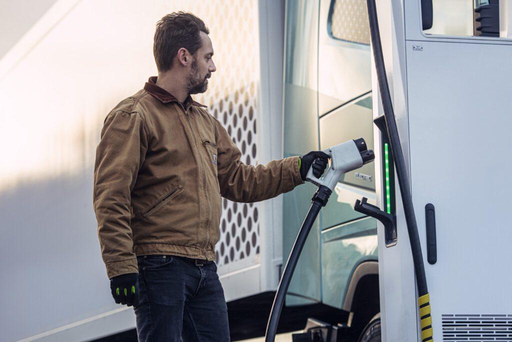 Man plugging EV charger into electric truck.