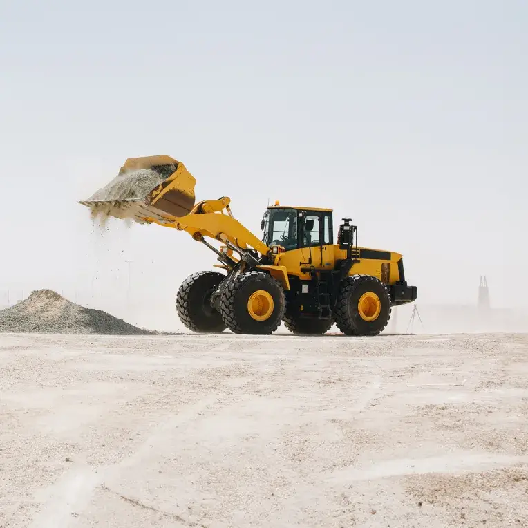 Yellow wheel loader moving aggregate on a construction site
