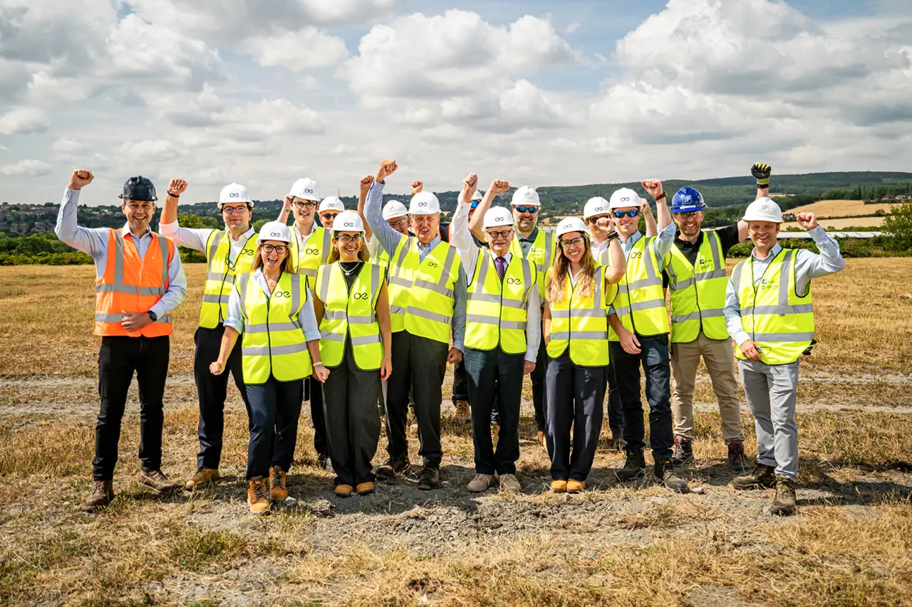 Happy and excited team wearing hard hats and high viz at the ground breaking of the first Aegis Energy hub in Sheffield.